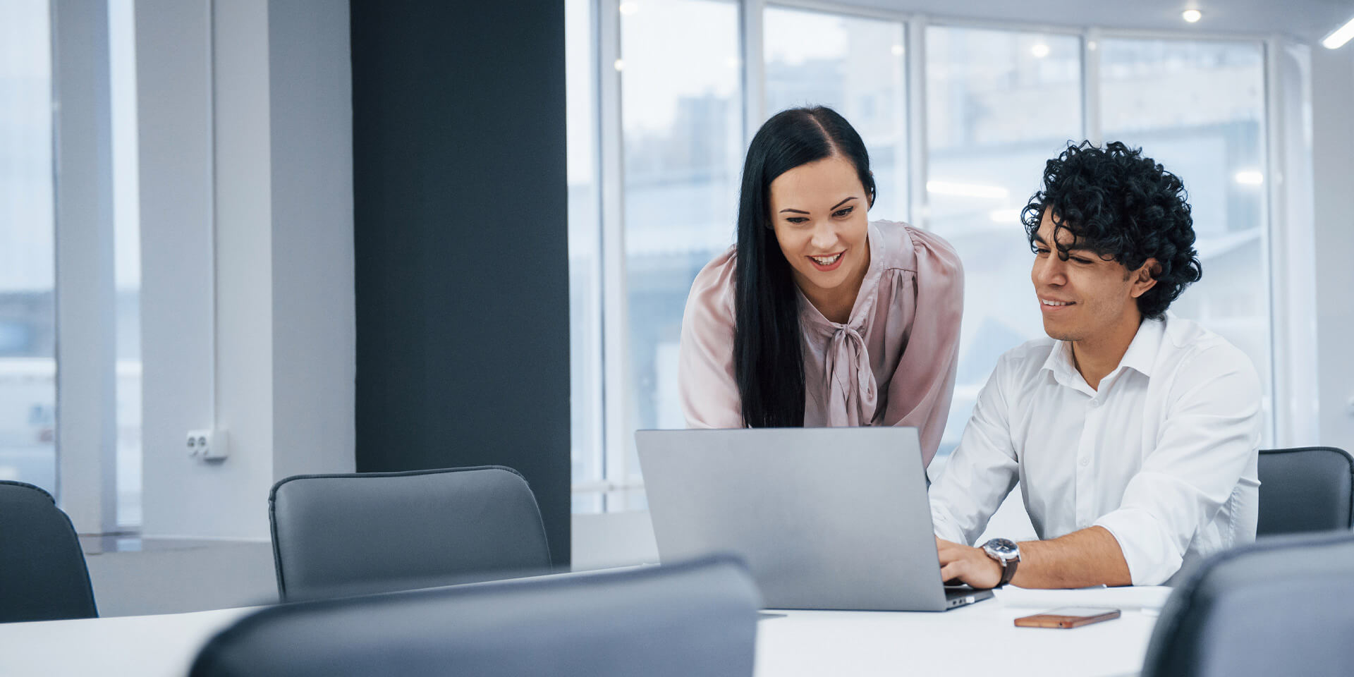 Two coworkers looking at a laptop